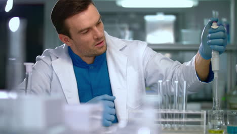 Scientist-man-using-pipette-in-lab.-Lab-worker-using-laboratory-equipment